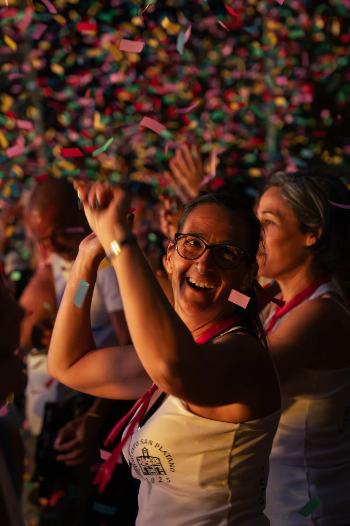 Donna ride tra il pubblico sotto la pioggia di coriandoli del Festival in Piazza