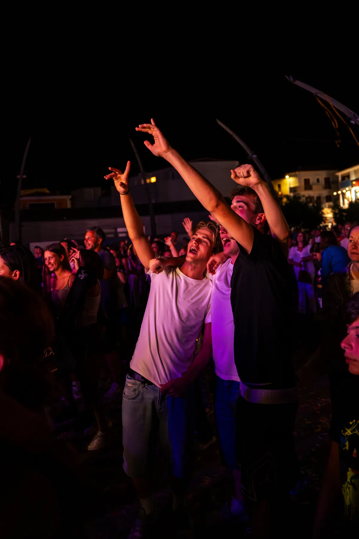 Ragazzi cantano a braccia alzate nelle luci del Festival in Piazza
