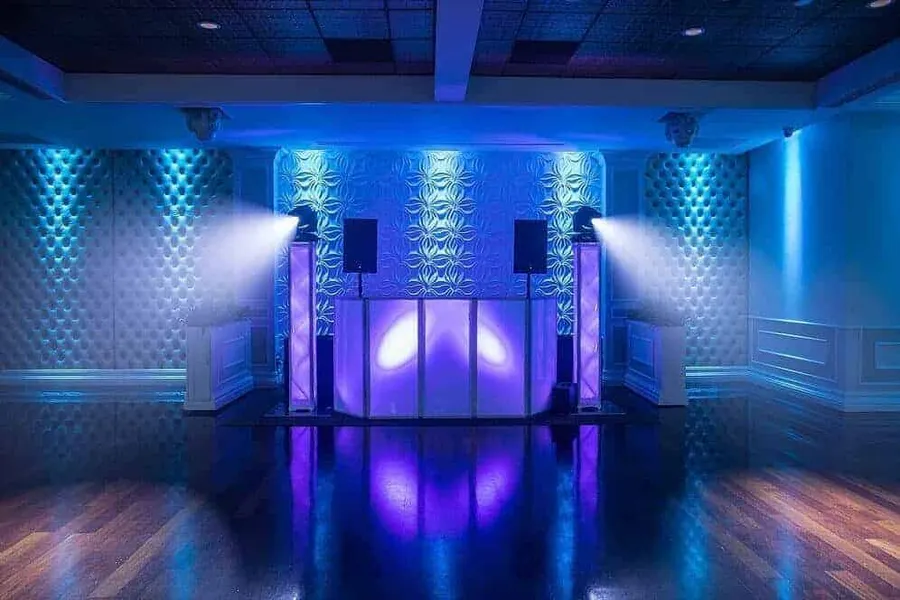 Consolle DJ illuminata di blu e viola pronta per la festa