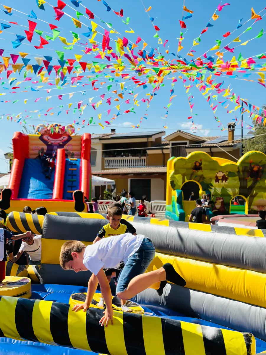 Bambini scavalcano i rulli gialli e neri del Meltdown durante una festa di piazza