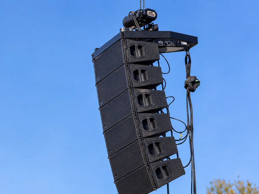 Line array di sei casse appeso al paranco a catena, sospeso contro il cielo
